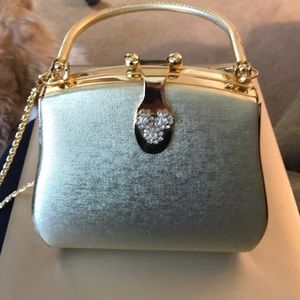 Hard shell gold purse w handle and chain.